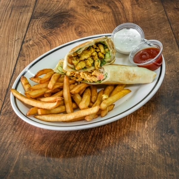 Middle-eastern chicken shawarma wrap with french fries, ketchup, and garlic sauce on a white plate.